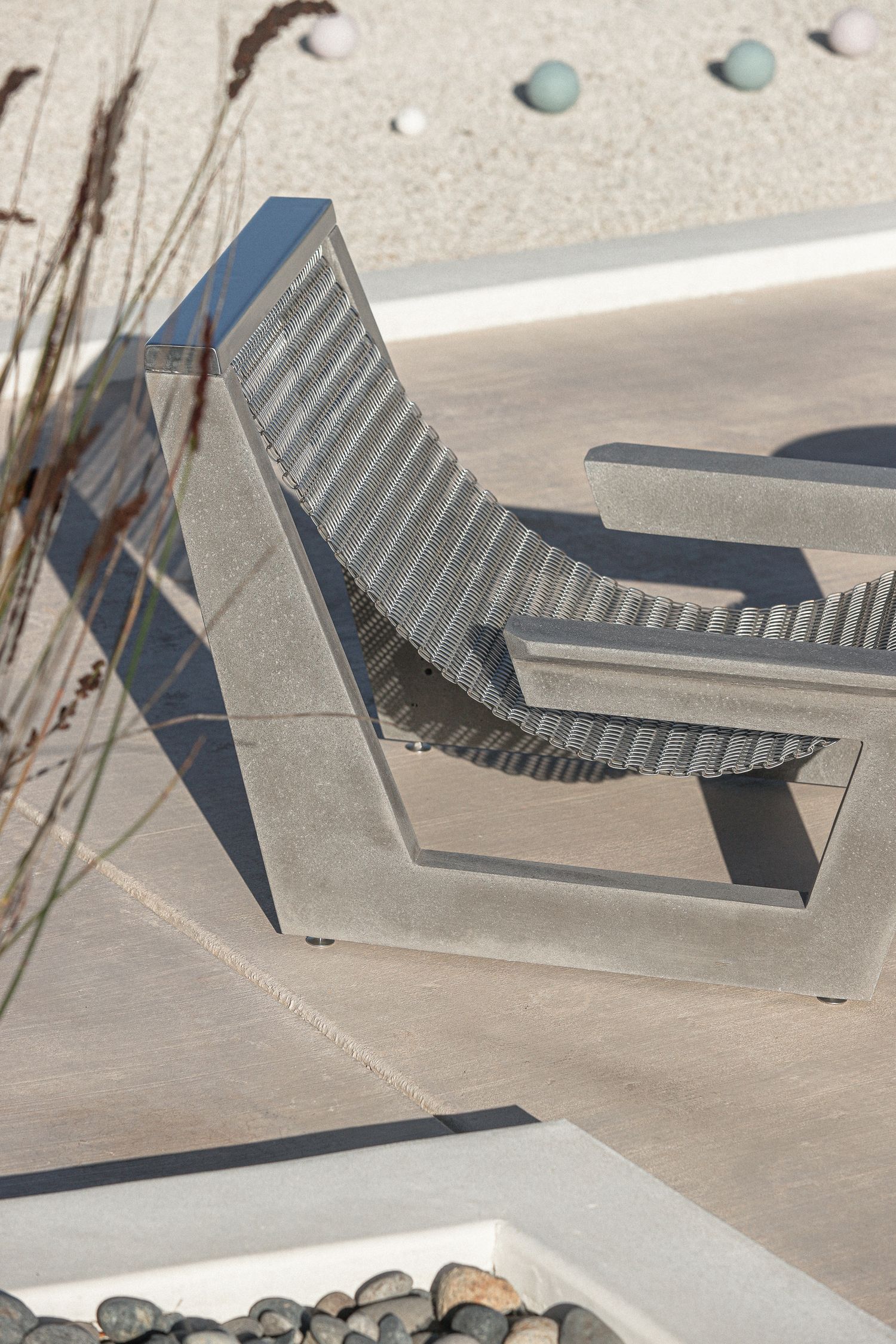 A series of small, minimalist architectural models made from gray materials arranged in a row on a light surface.