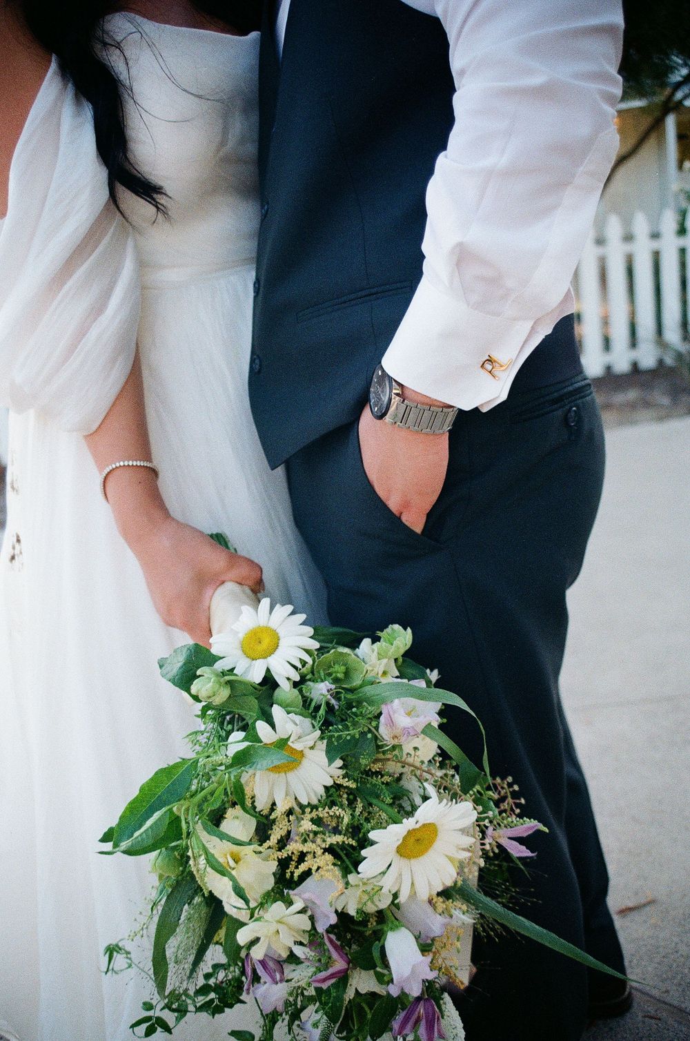 Close-up film photograph of the groom’s vintage watch and the bride’s bouquet at an Orange County wedding.