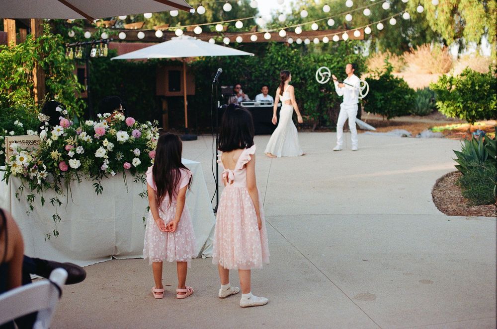 Candid film photography by an Orange County wedding photographer of children watching the cultural dancers at the reception.
