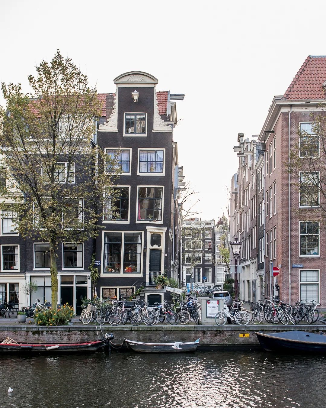 Traditional Amsterdam canal houses reflected in the water on an autumn day.