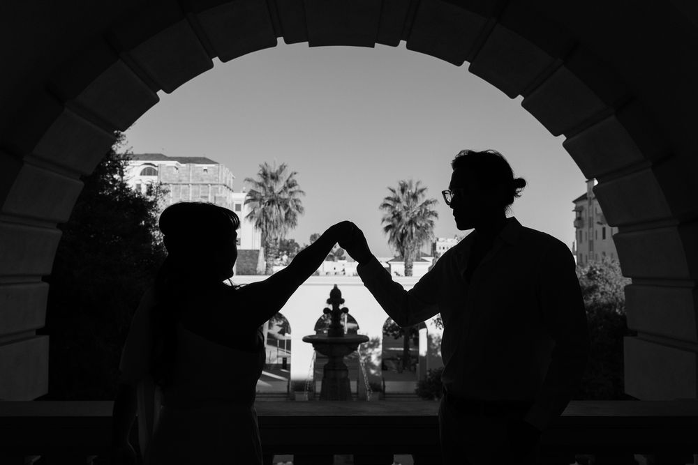 Backlit photo of couple at golden hour, soft flares at Pasadena City Hall.