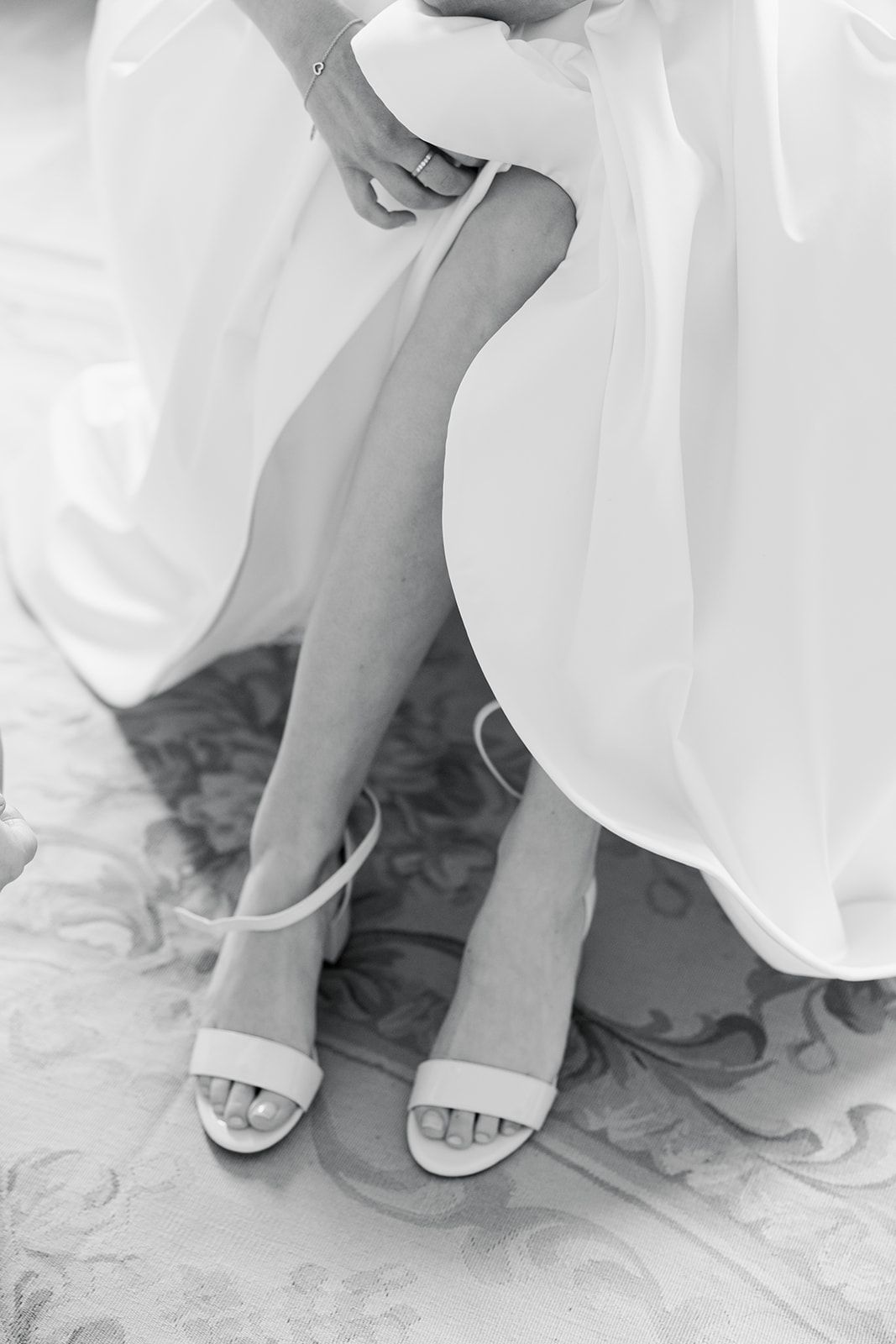 White wedding dresses hanging on display in a sunlit bridal boutique with sheer curtains and elegant decor.