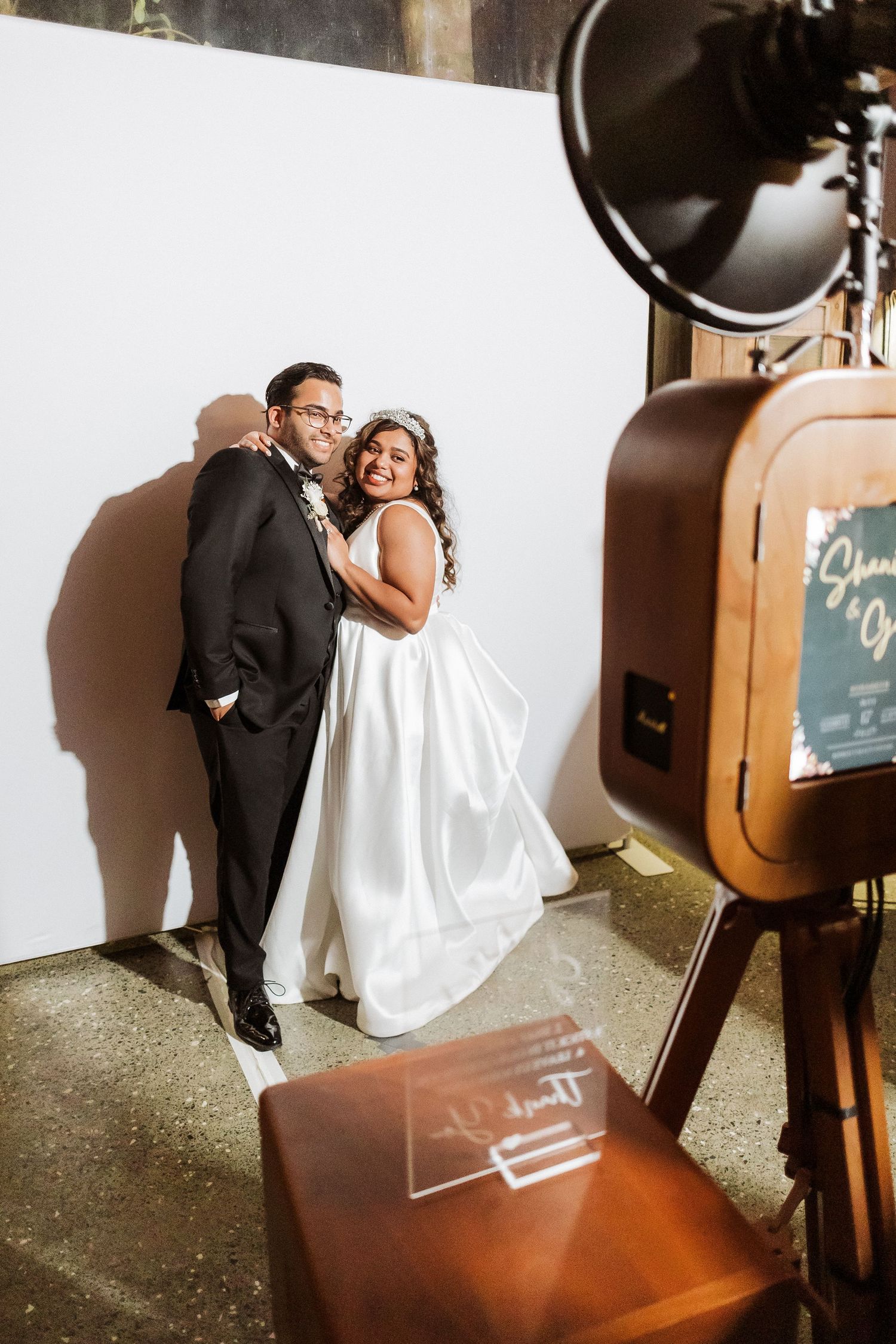 A couple shares an intimate moment while sitting on wooden stairs in an indoor venue.