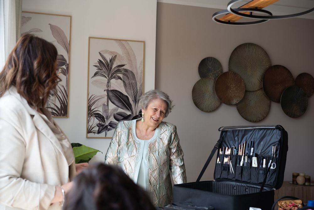 Getting ready scene in a bright room with tropical decor and palm art on the wall.