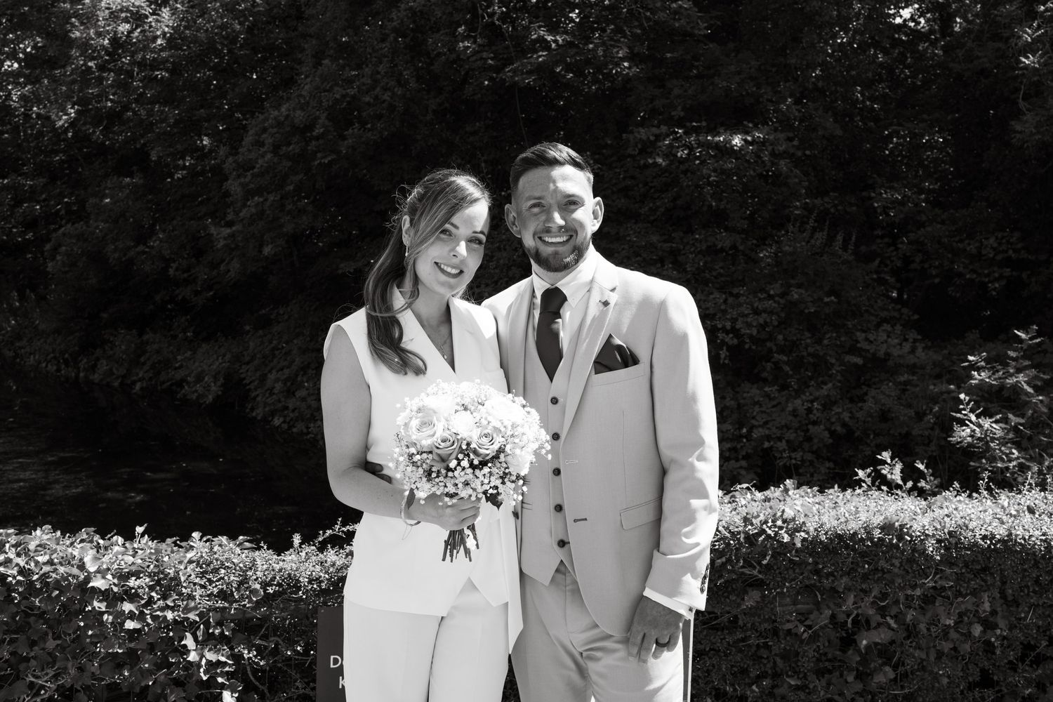 A collection of black and white wedding photos showing couples posing outdoors in formal attire.