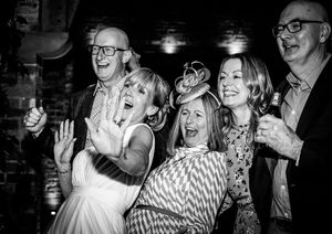 Black and white photos capturing joyful dancing and celebration moments at a wedding reception.