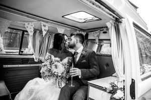Inside a vintage VW van decorated for a wedding with white floral arrangements.