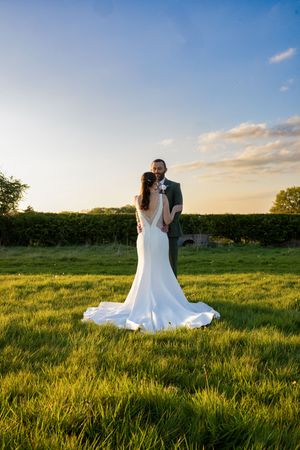 Sunset wedding photo sequence in a grassy field with warm golden light.
