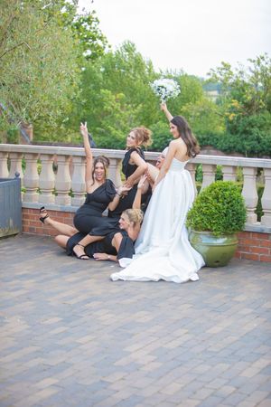 A sequence of fun poses captured on an outdoor terrace with stone railing and greenery in the background.
