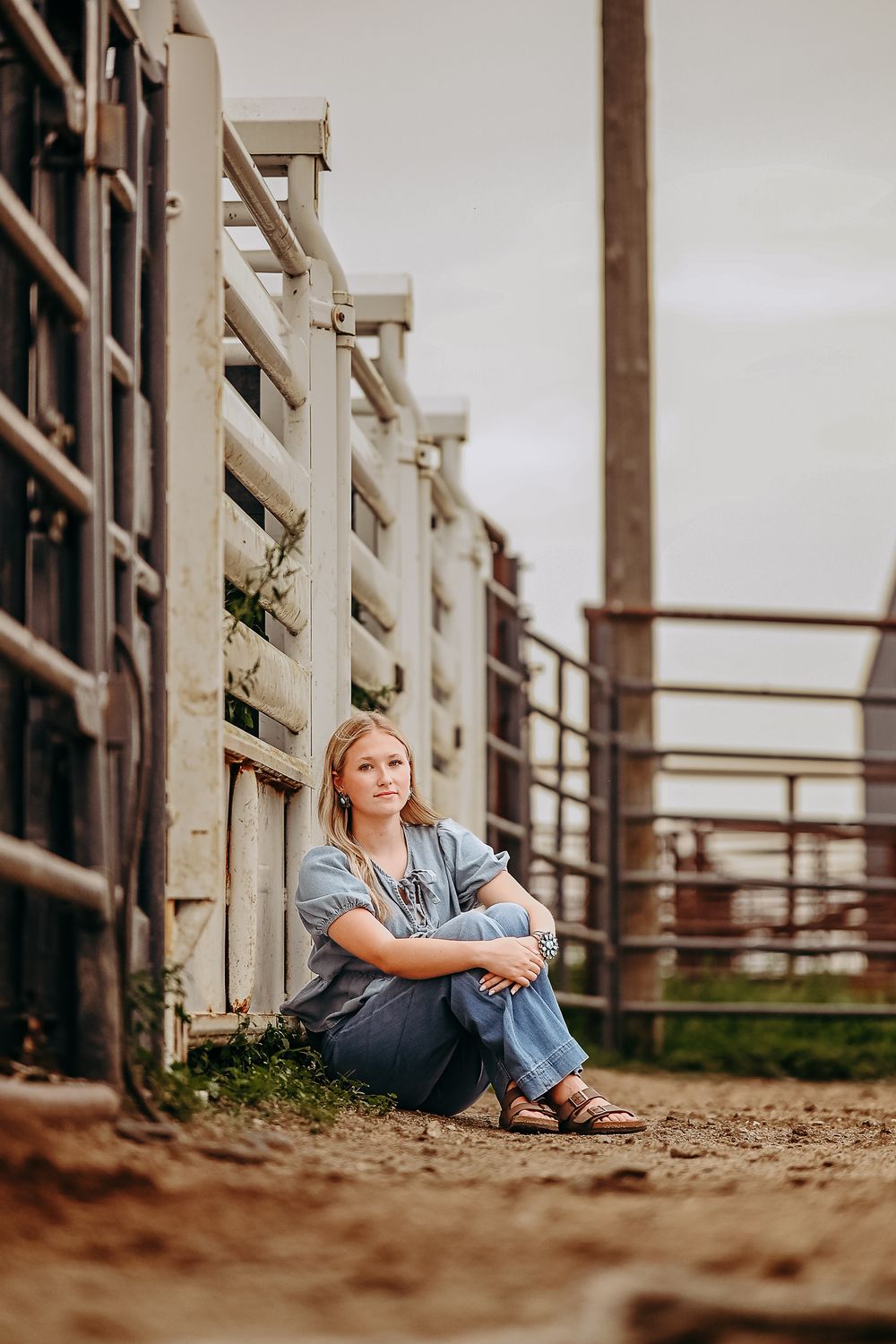 A person sits contemplatively along a rustic wooden fence on a dirt path, shown in a series of similar perspectives.
