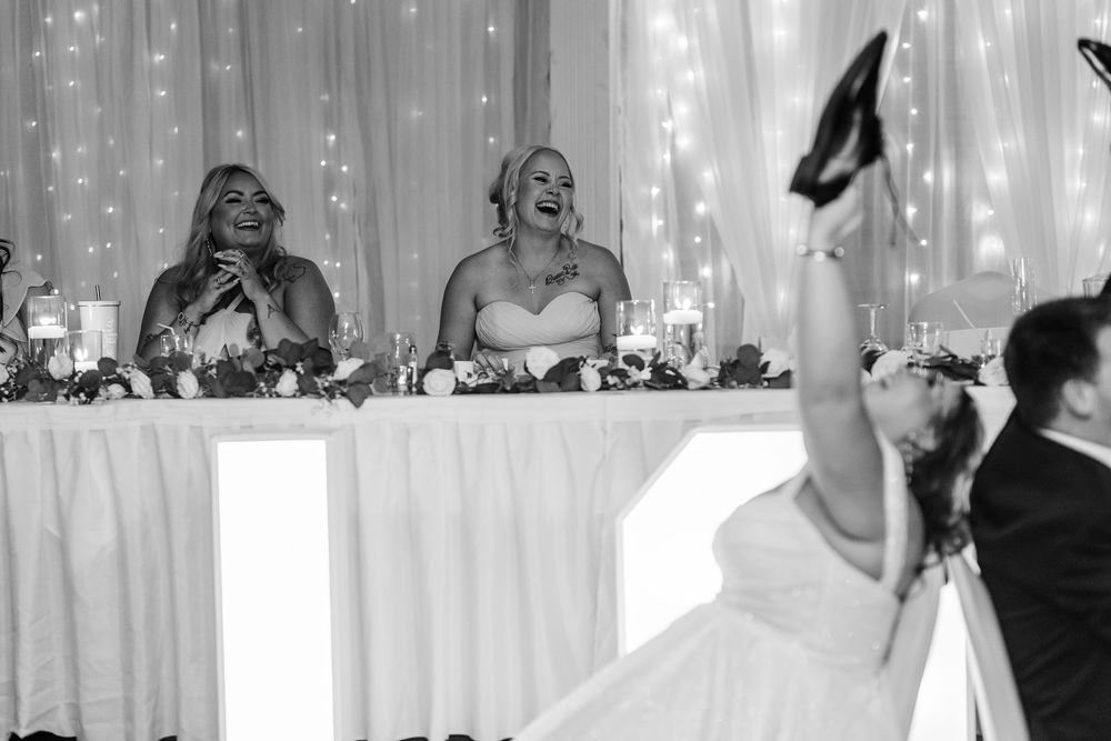 A couple shares a sweet moment during their wedding dance on the dance floor with a sparkly backdrop.