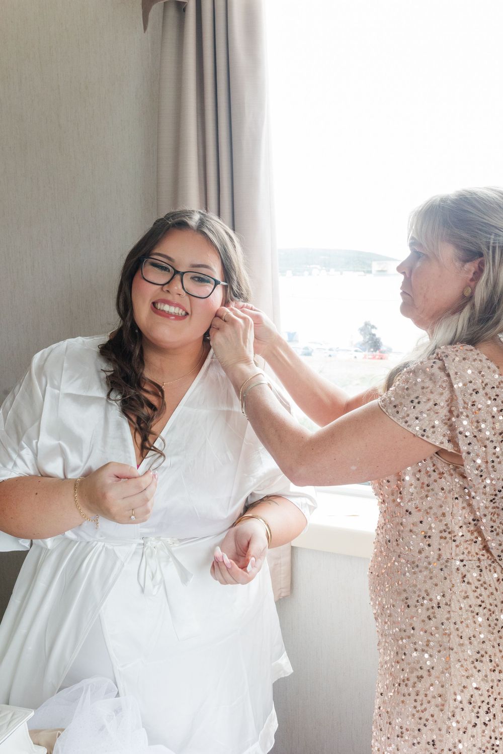 A sequence of photos showing joyful getting ready moments with someone in a white wedding dress and companion in beige.