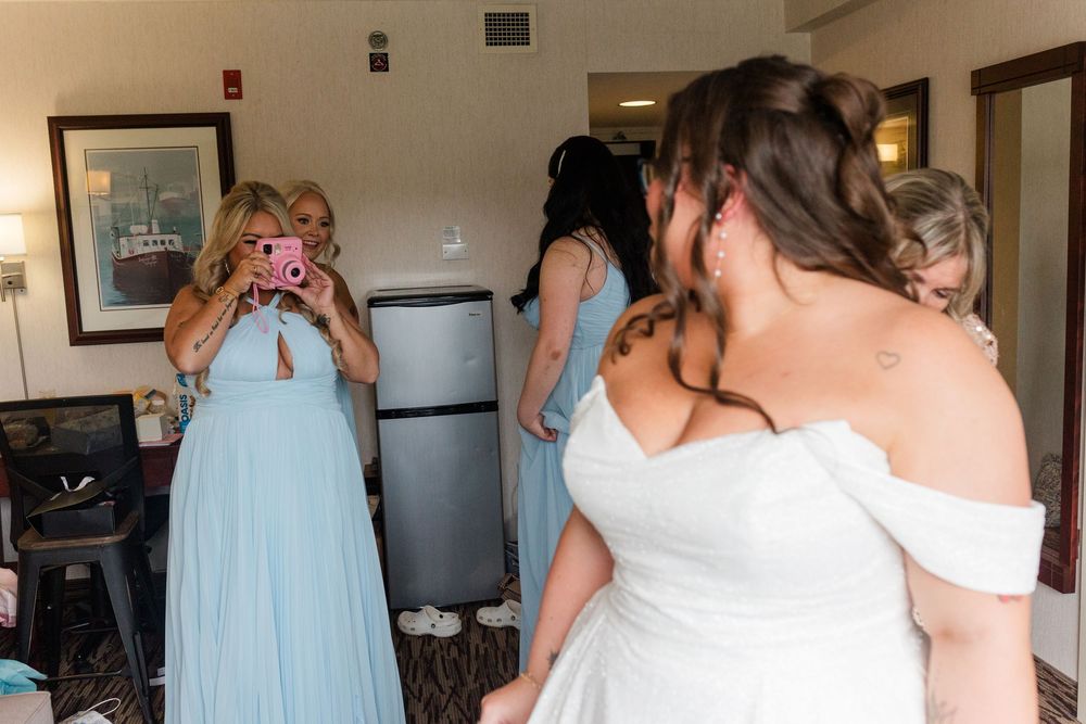 Candid moments of wedding preparations with bridesmaids helping the bride in a light-filled room.