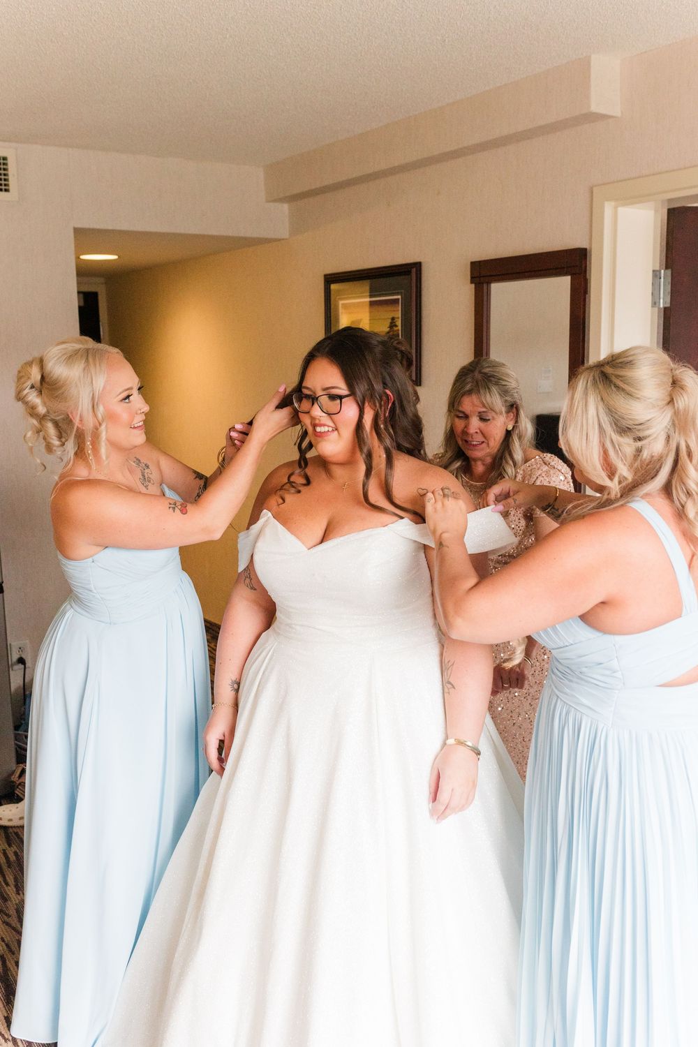 Group wearing matching powder blue bridesmaid dresses standing together at a wedding celebration.