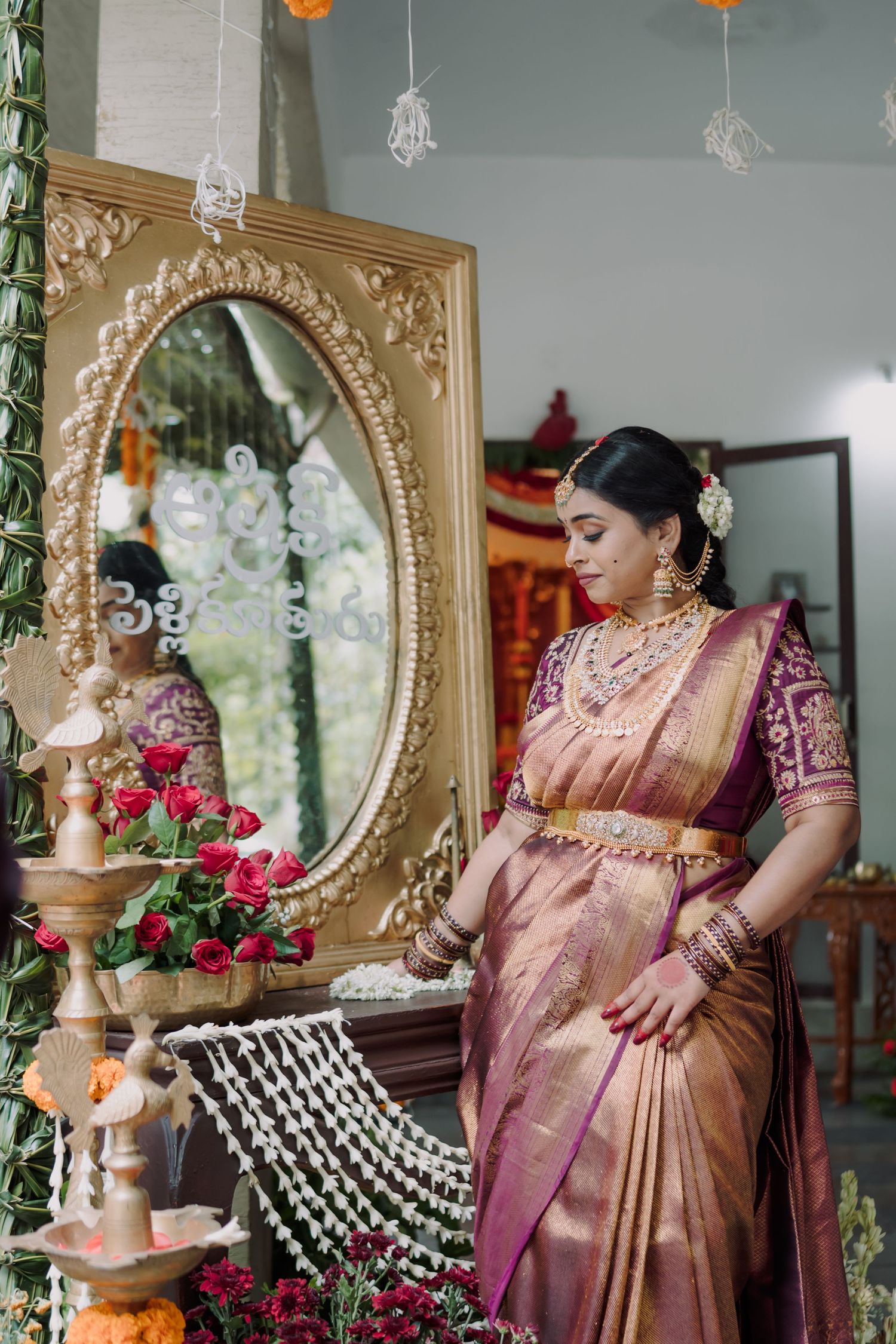 A collection of photos showing traditional Indian bride in pink silk saree getting ready with traditional jewelry and decor.