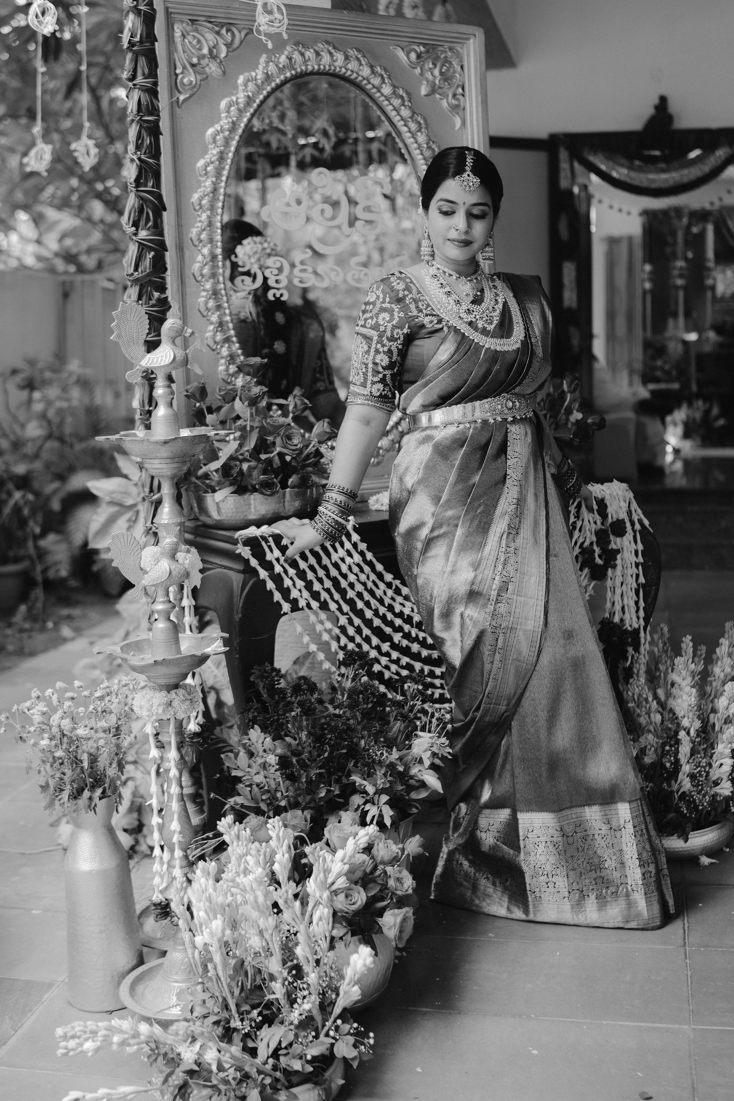 Black and white photos show a traditional Indian bride getting ready with floral decorations and wedding preparations.