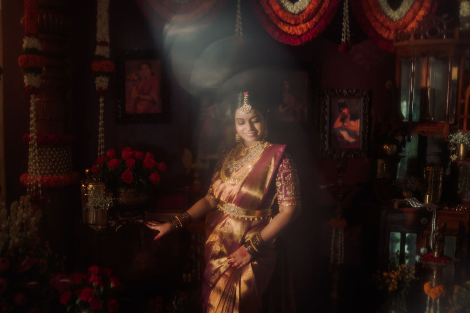 A theatrical performer in traditional Thai costume and headdress dances onstage in dramatic red lighting.