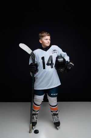 A young hockey player in a white jersey and gear shoots a puck against a dark background in a series of action shots.