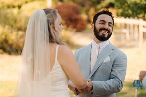 A couple shares tender moments during their outdoor wedding photoshoot against a warm sunset backdrop.