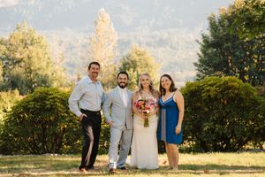 People enjoying outdoor photo session in golden sunlight on grassy field with trees in background.