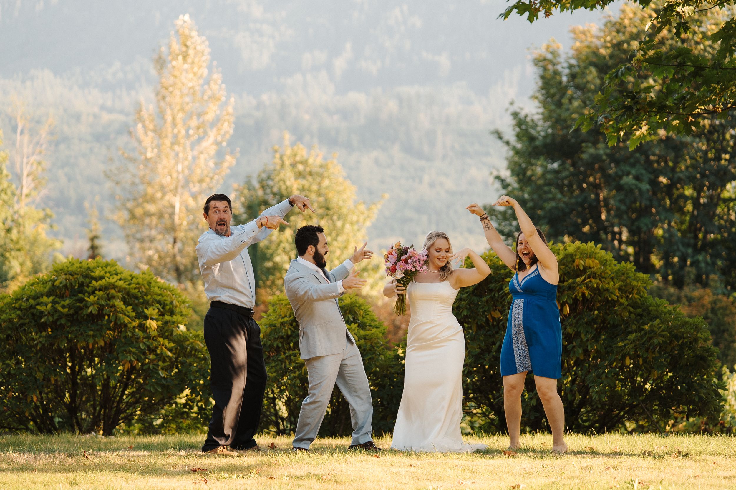 Group playfully jumping together during sunset outdoor photo session in nature setting.