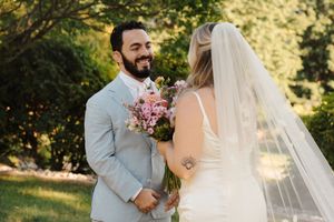 A romantic wedding photoshoot in a sun-drenched garden setting capturing tender moments between the newlyweds.