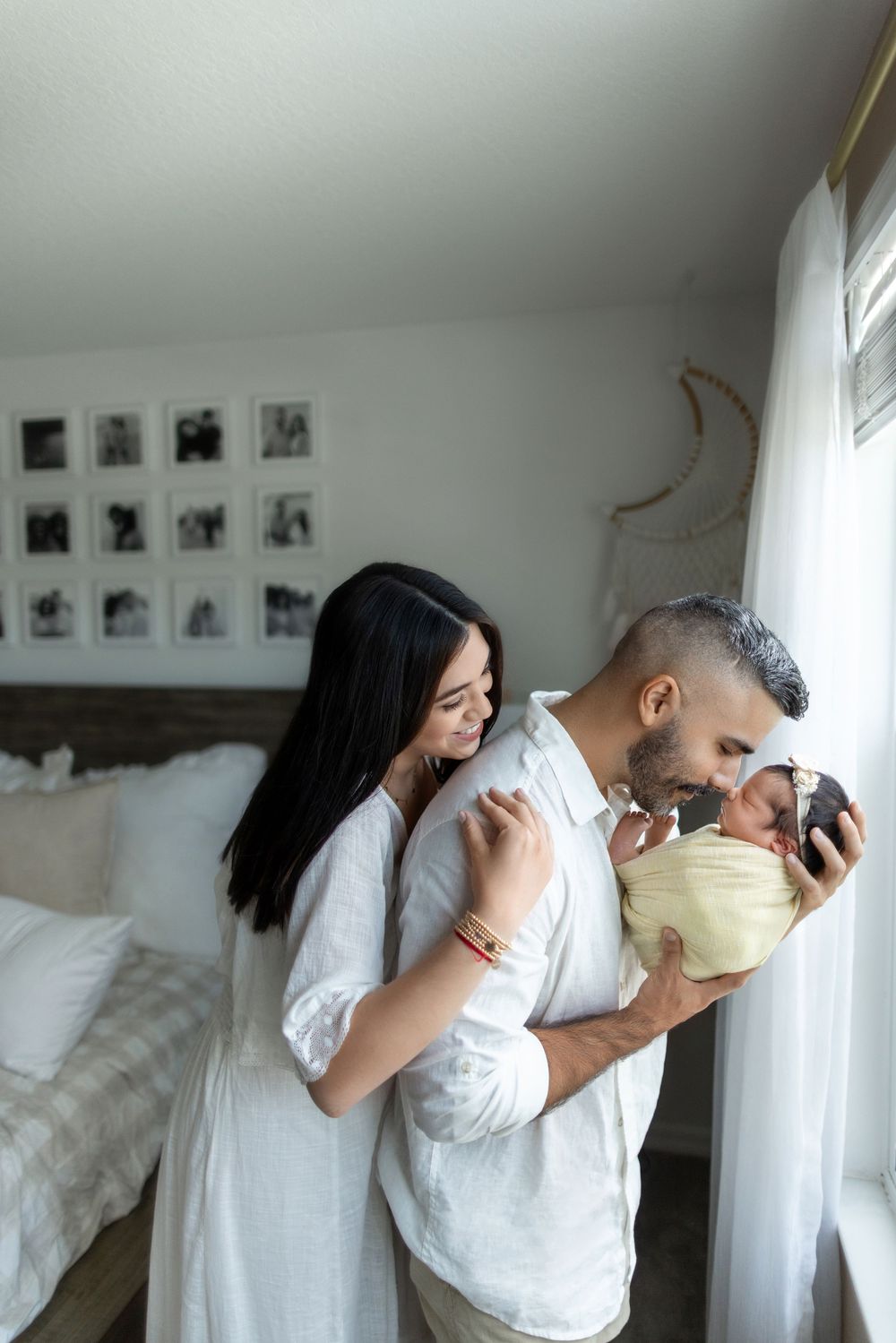 Multiple images of a couple in white clothing embracing in an intimate artistic photoshoot against white walls.