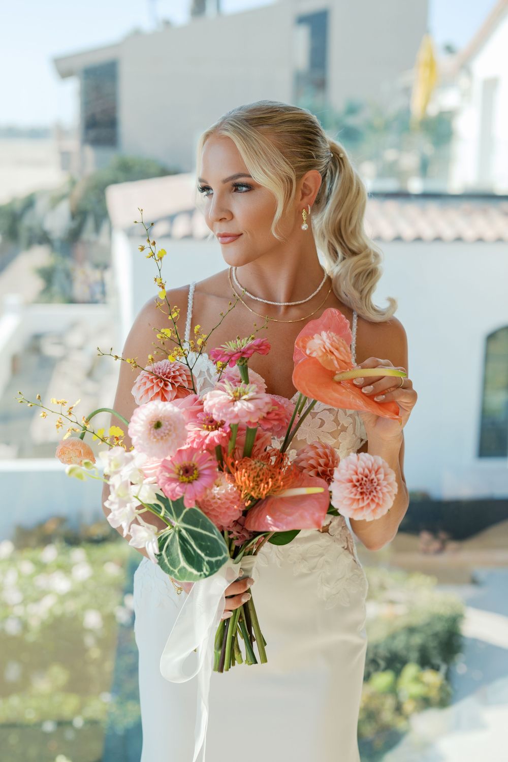 An elegant bridal bouquet with coral dahlias and delicate greenery in natural sunlight.