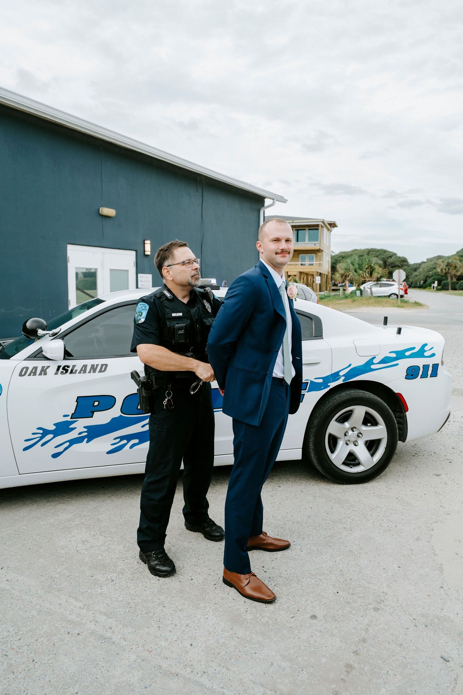 A sequence showing a police officer playfully handcuffing someone in front of a police car.