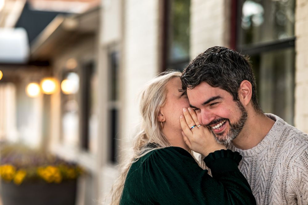 A couple shares a tender romantic moment while sitting together at a restaurant.
