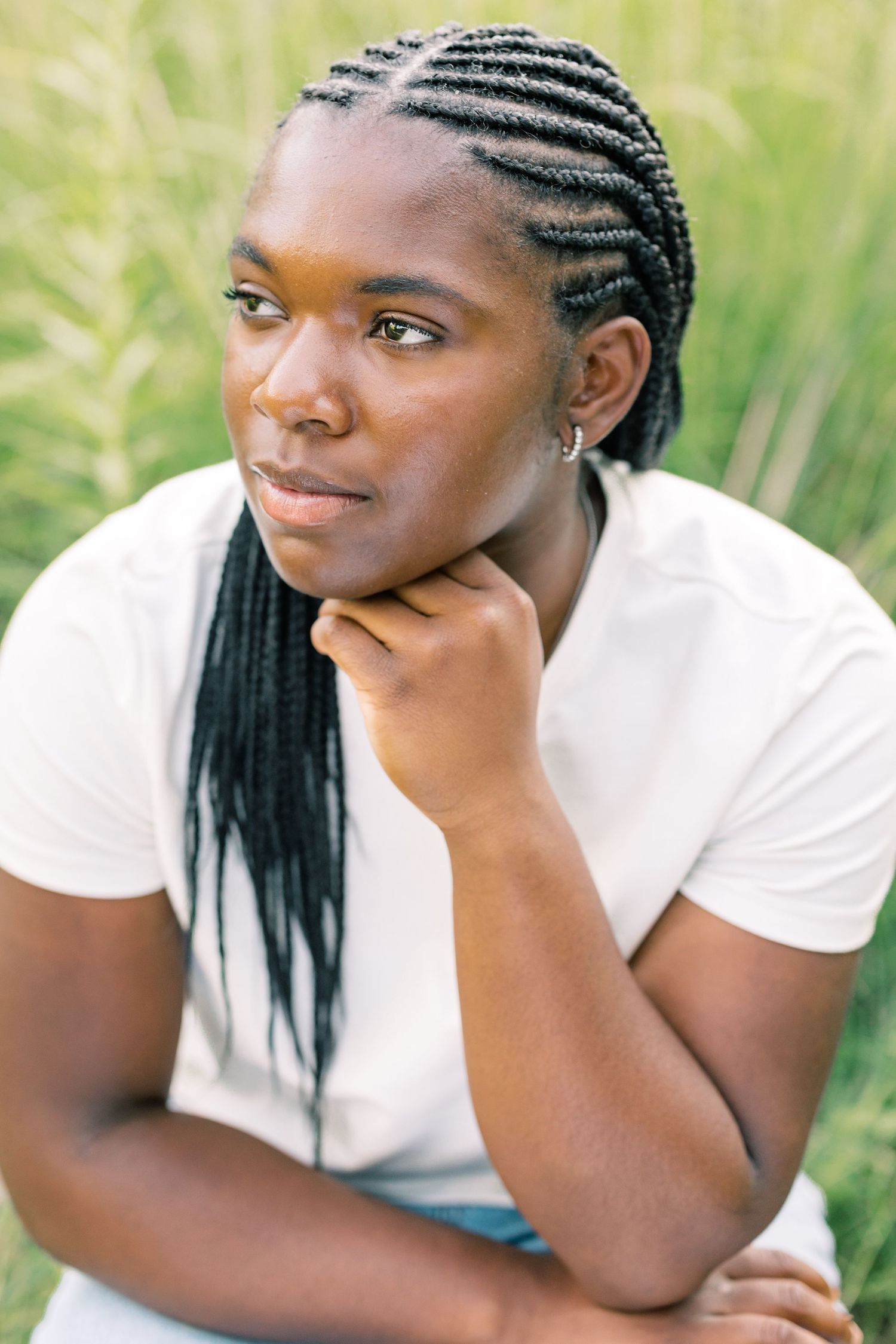 A series of outdoor portrait shots showing a person in a white t-shirt resting their chin on their hand in tall grass.
