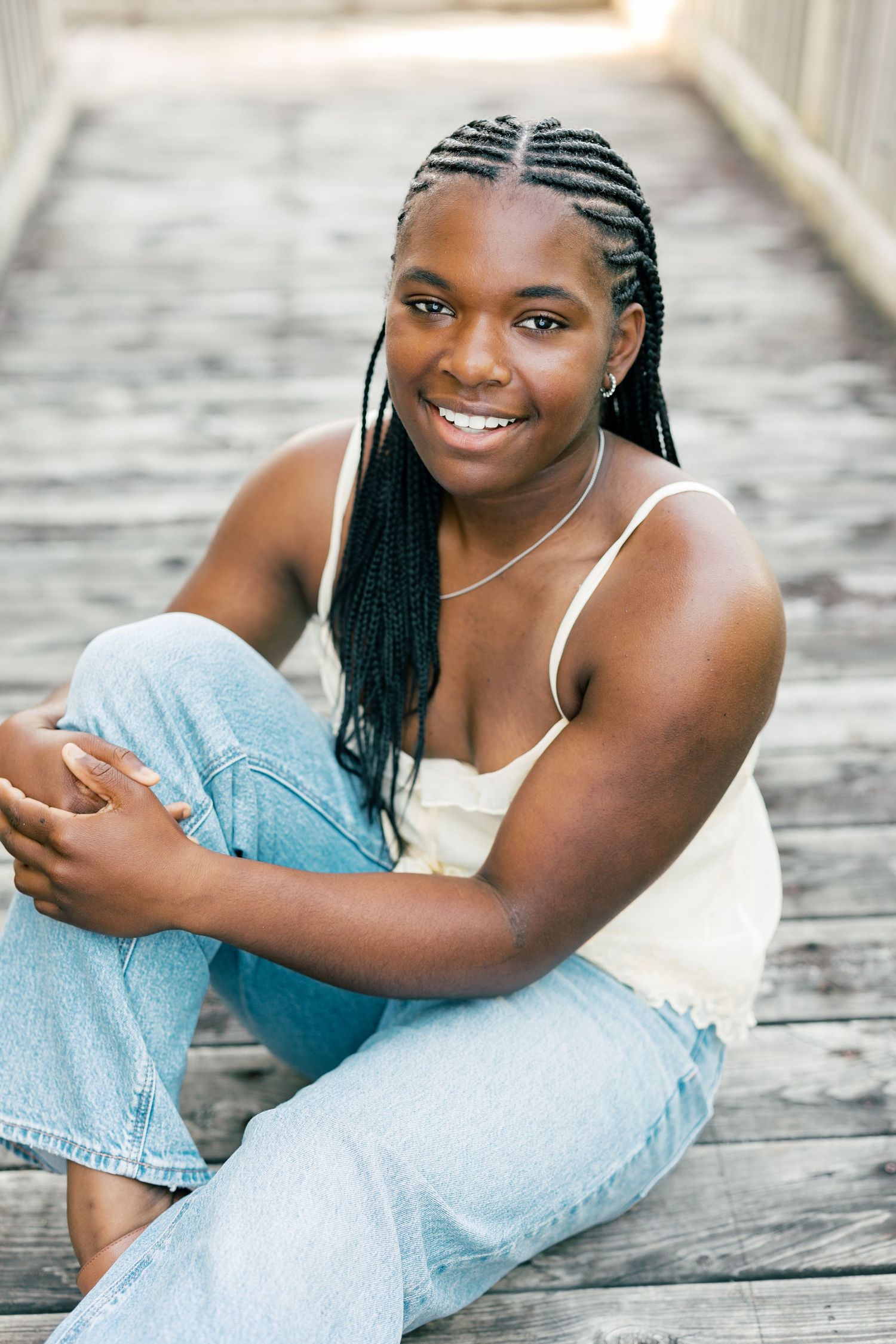 A candid portrait series shows a subject sitting on wooden decking in light denim and a white top.