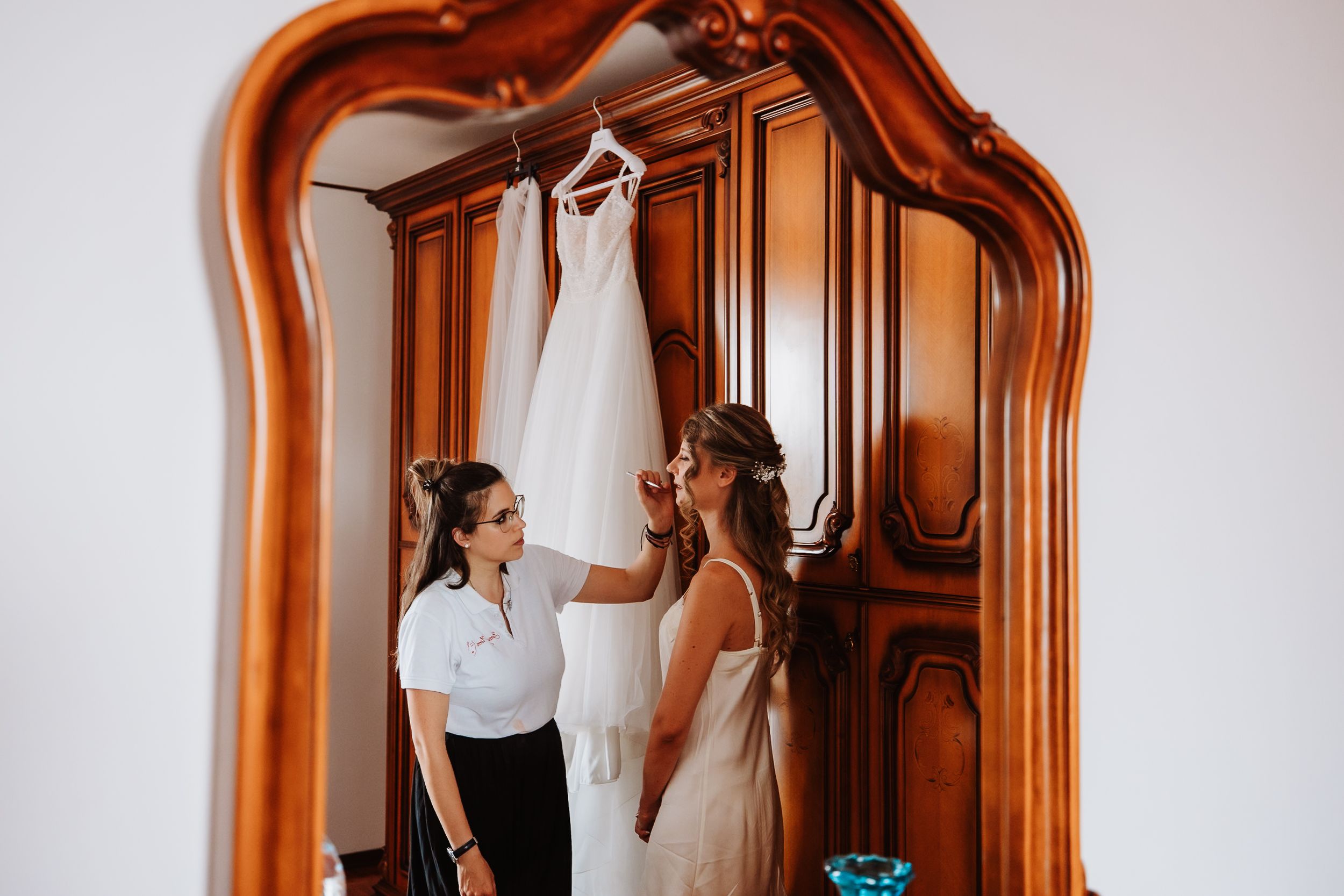 Wedding couple shares intimate moment in venue corridor with beautiful wooden archway and natural light.