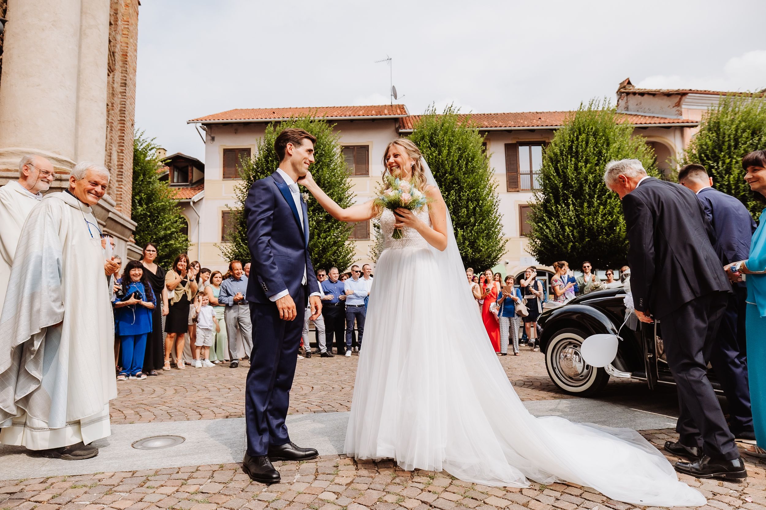 Outdoor wedding ceremony in progress against Spanish colonial architecture backdrop during golden hour.