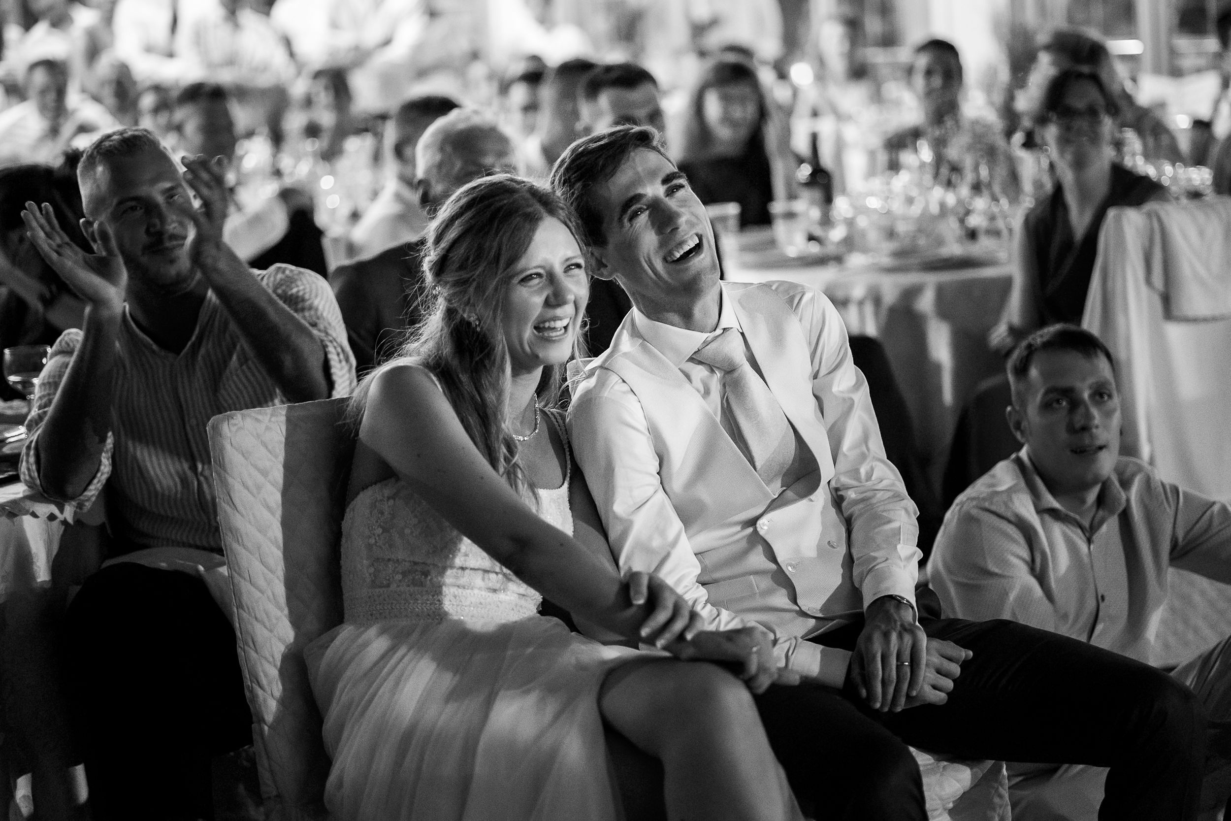 Black and white photo of wedding guests enjoying the reception celebration.