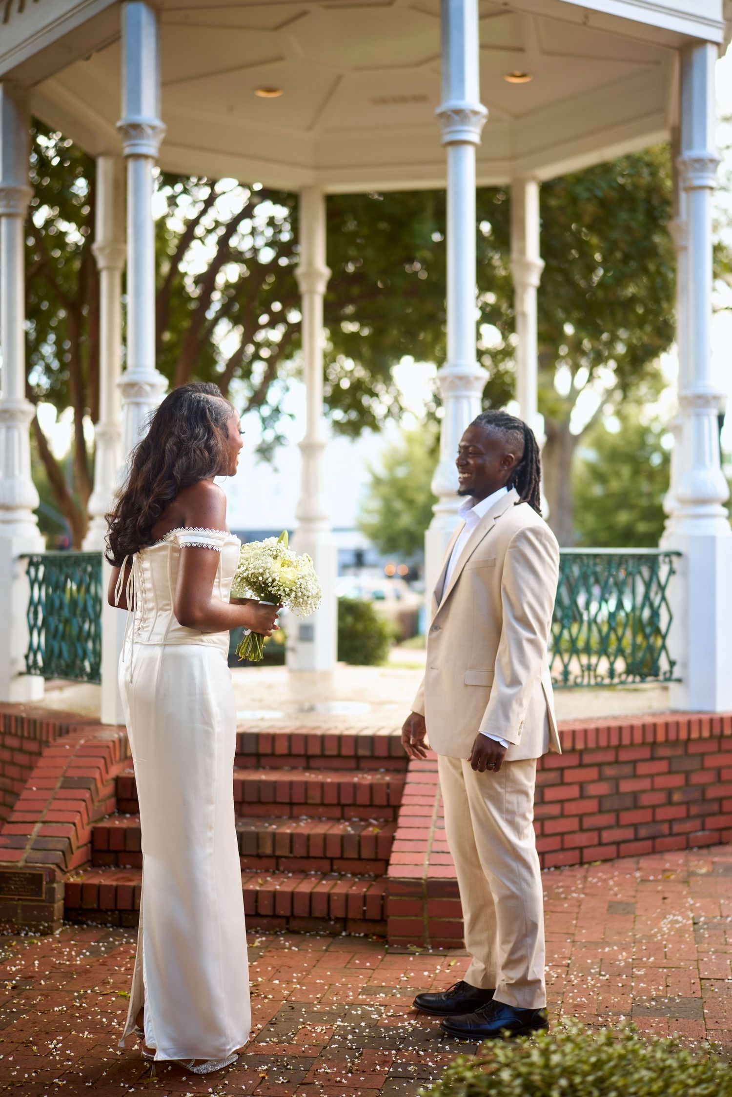 A series of romantic wedding photos captured under a white gazebo with ornate columns and brick foundation.
