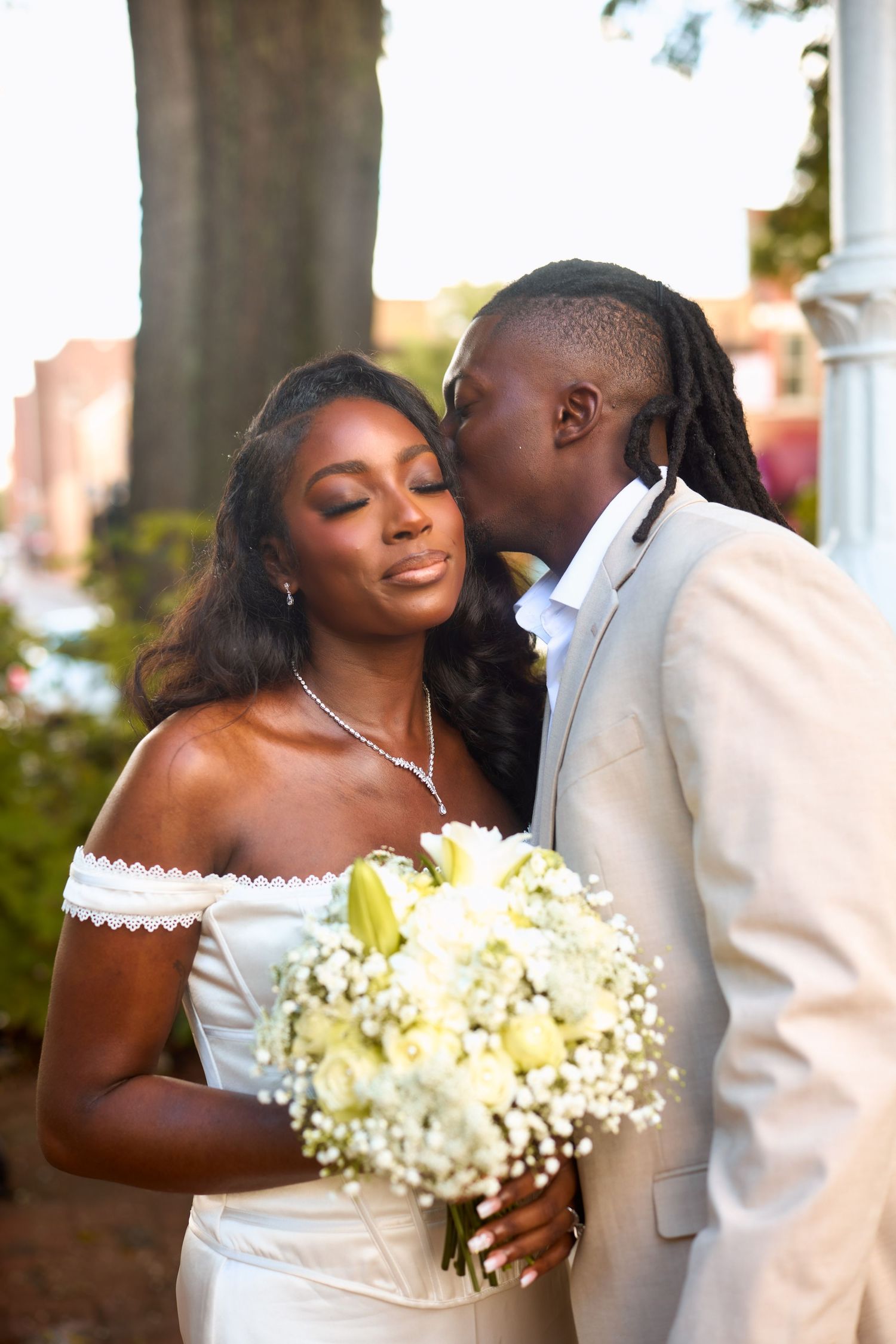 A romantic wedding photoshoot sequence showing a couple sharing tender moments with white floral bouquet accents.