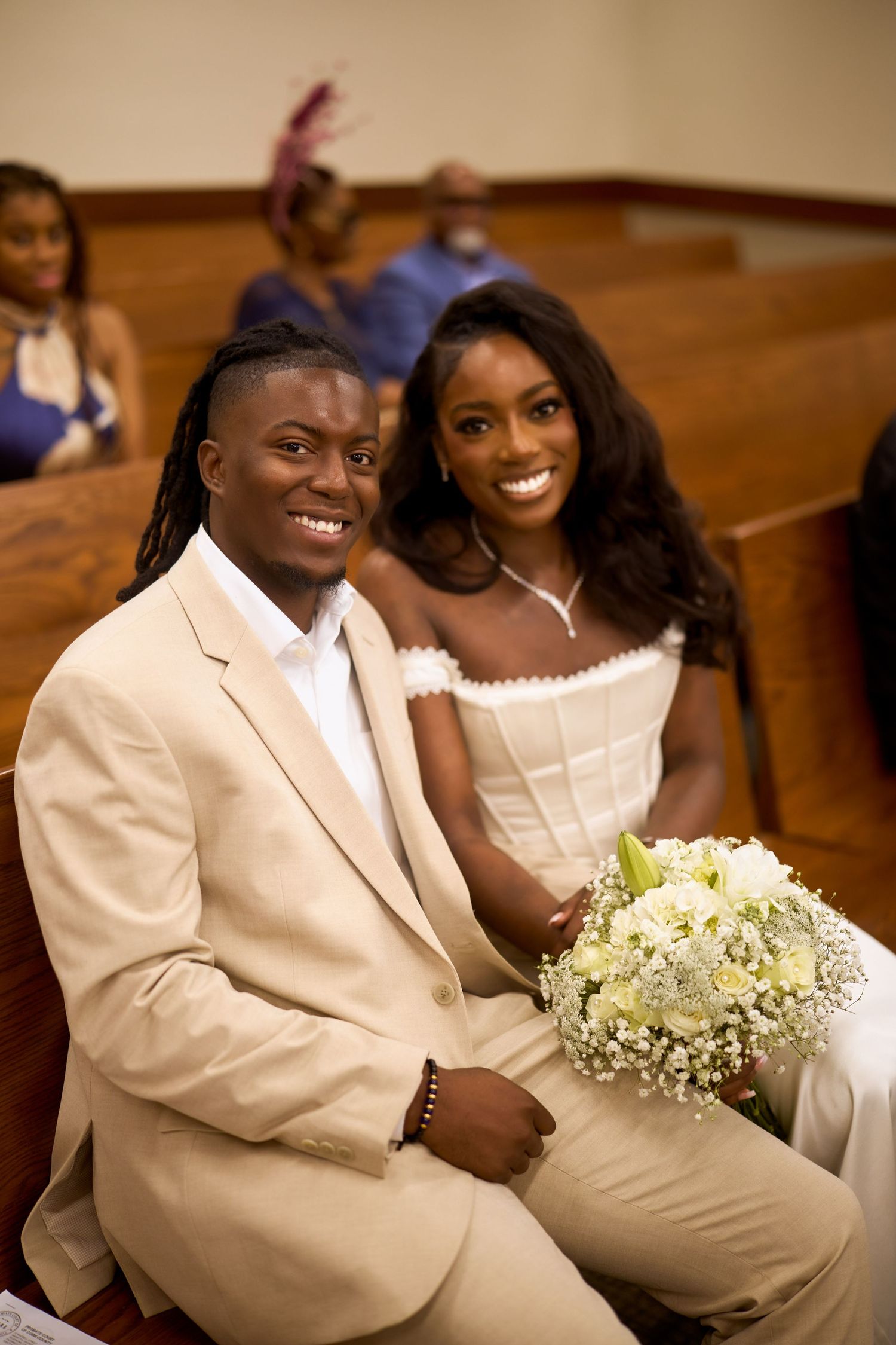Joyful couple shares intimate moments in light beige formal attire during their wedding ceremony.