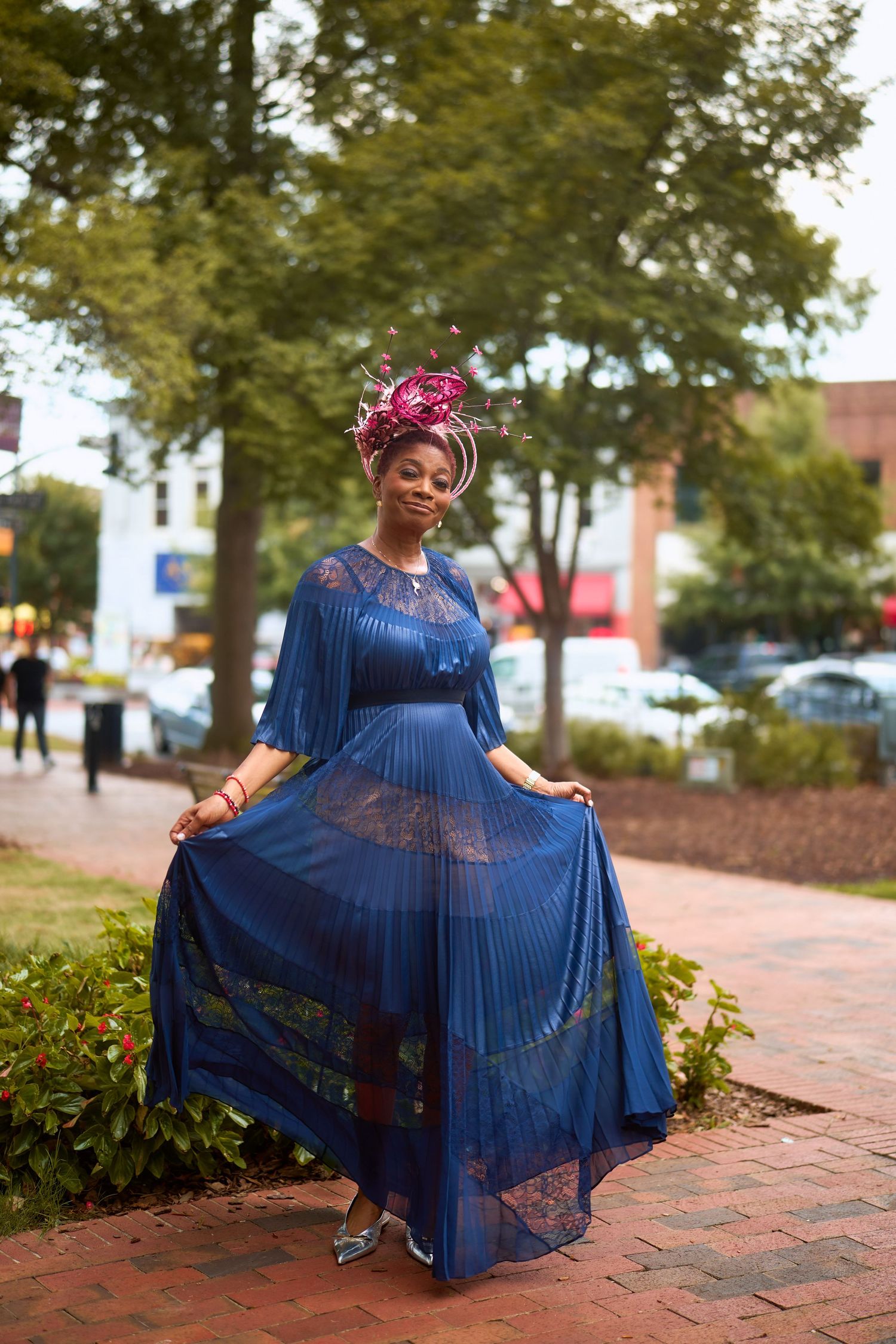 A graceful spinning motion captured in sequence showing a flowing blue dress twirling on brick pavement.