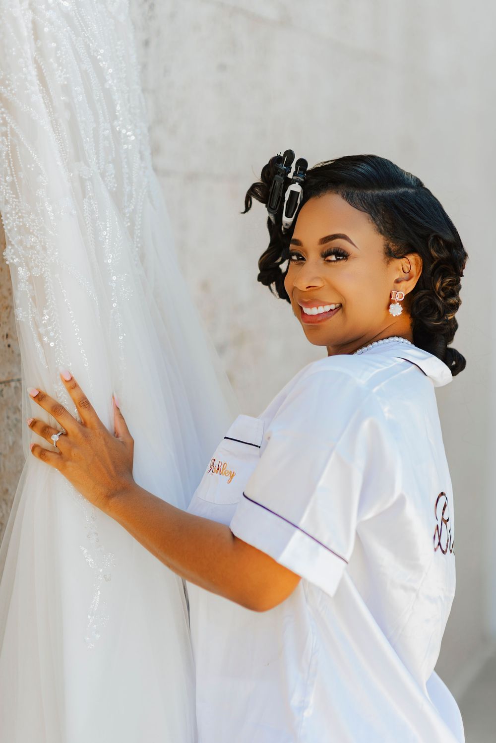Joyful poses against a light backdrop wearing a white collared shirt.