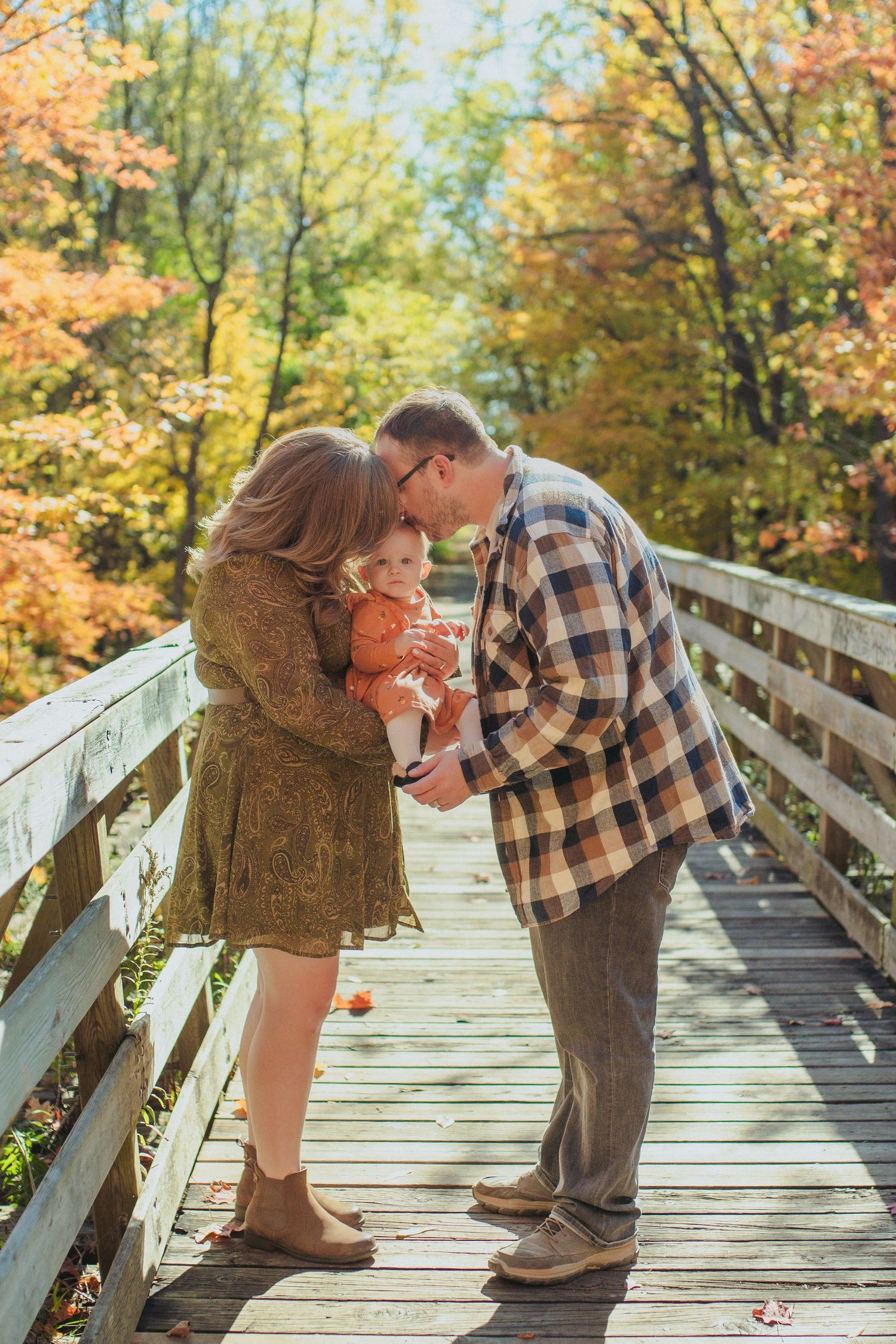 A romantic autumn moment captured in a sequence of photos on a wooden bridge surrounded by fall foliage.