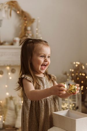 Joyful moment during holiday decorating with sparkly lights and festive atmosphere.