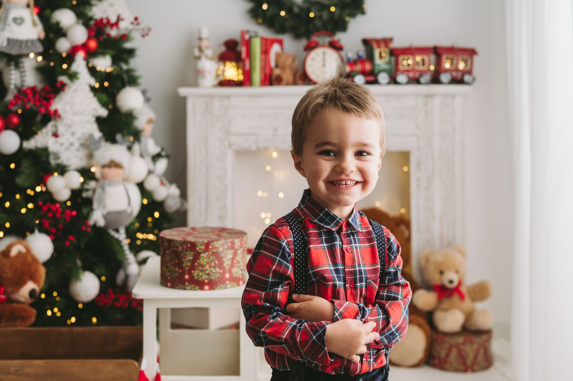 Christmas scene with decorated tree and white fireplace mantel.