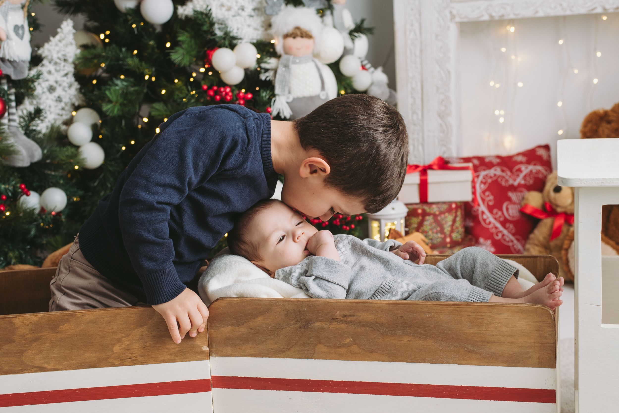 Sweet moment captured by Christmas tree with decorations and gifts.