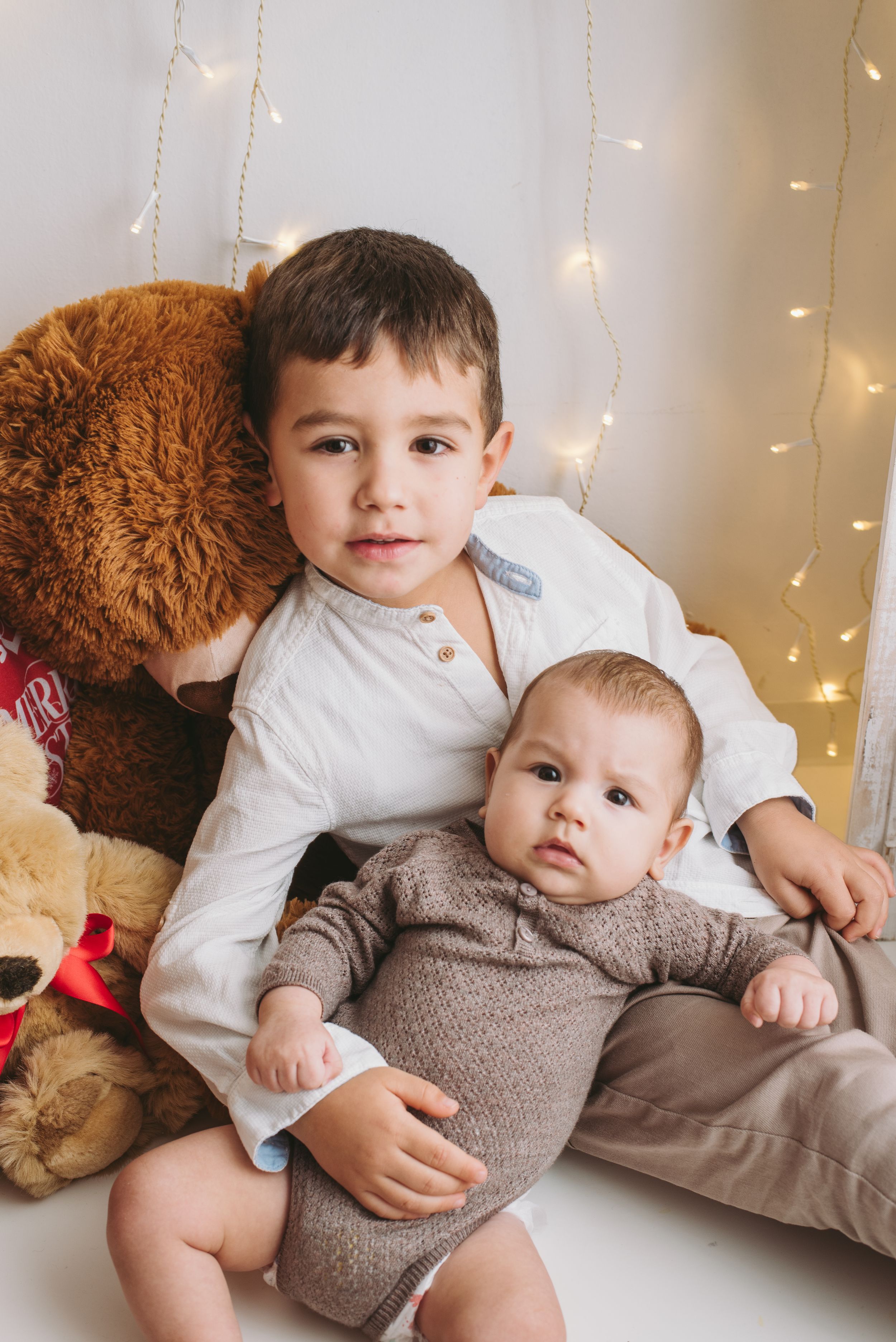 Cozy Christmas scene with teddy bears and string lights.
