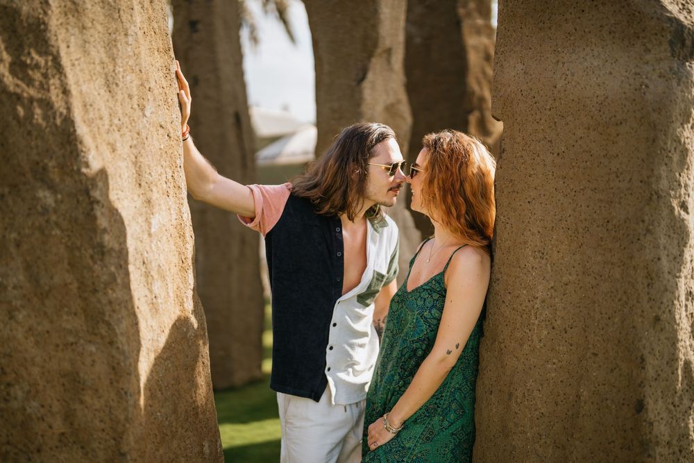 Intimate moment captured against a stone wall backdrop in natural lighting.