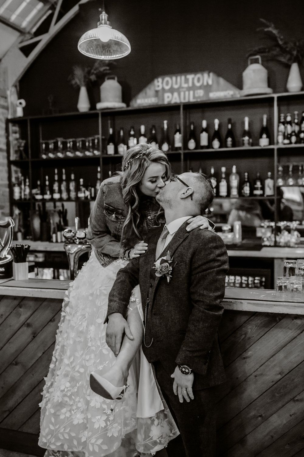 A romantic couple shares intimate moments at a vintage bar counter in a series of black and white photographs.