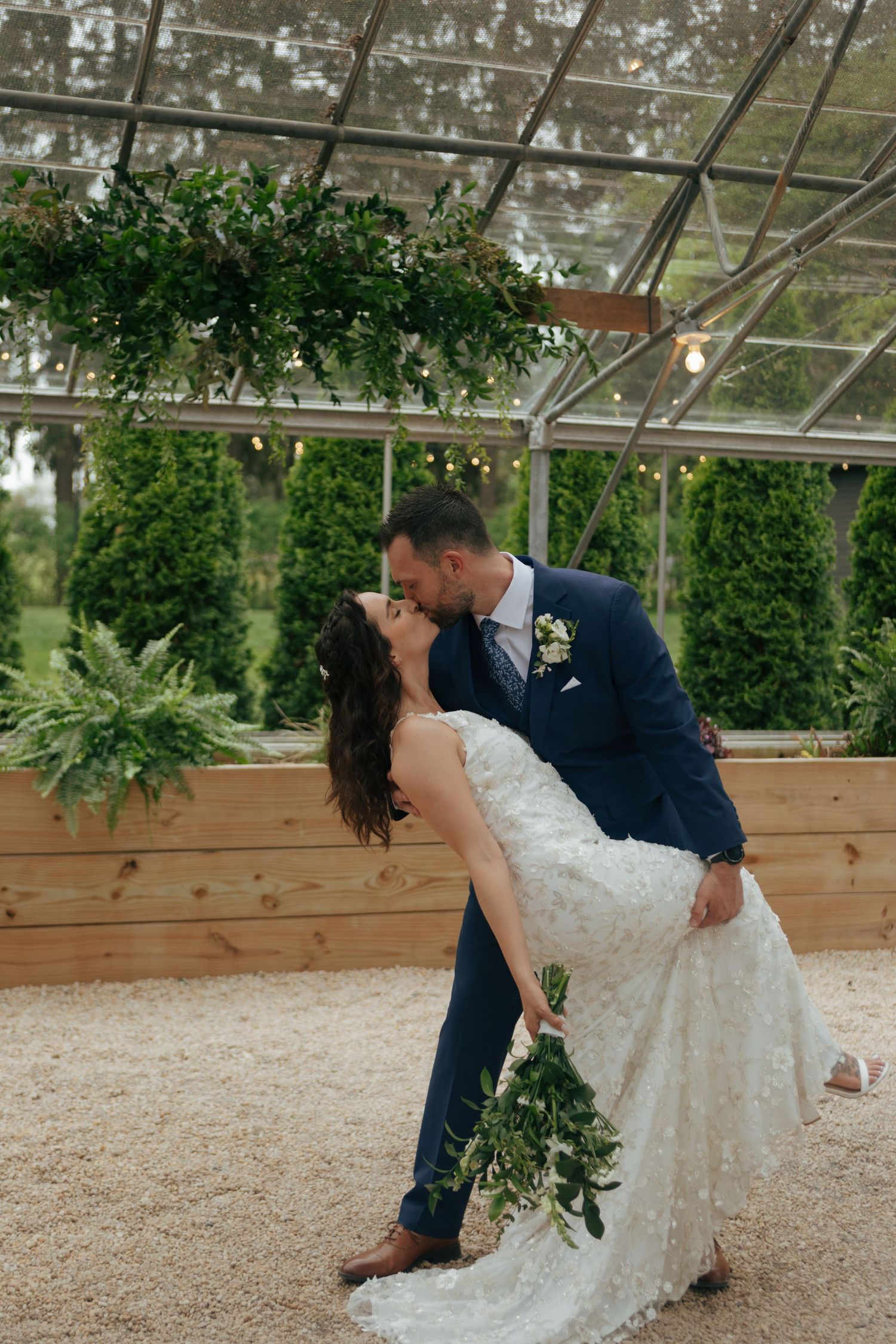 Panoramic sequence of romantic dip pose in greenhouse setting with wooden planters and greenery.