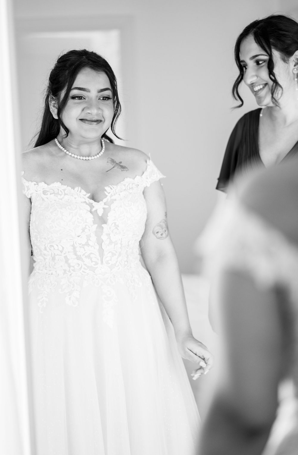 A bride in a beautiful white lace wedding dress poses elegantly in a series of black and white portraits.