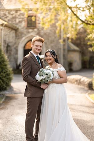 A romantic wedding couple shares tender moments in an outdoor autumn setting with golden light and stone architecture.